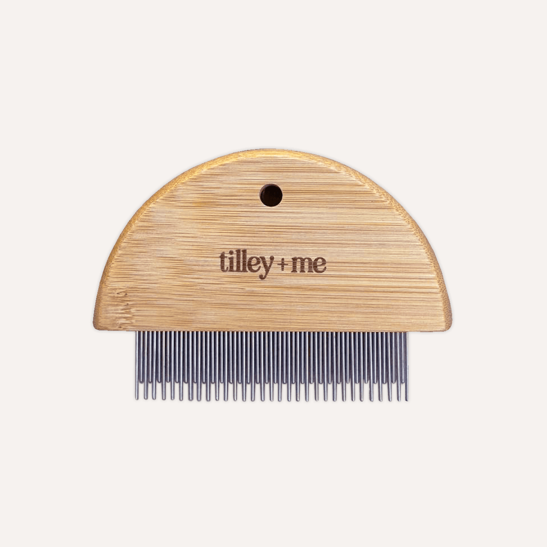 Wooden comb with metal teeth on a white background, featuring the brand 'tilley + me'.