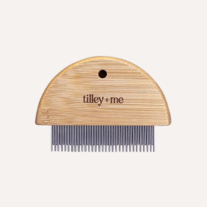 Wooden comb with metal teeth on a white background, featuring the brand &
