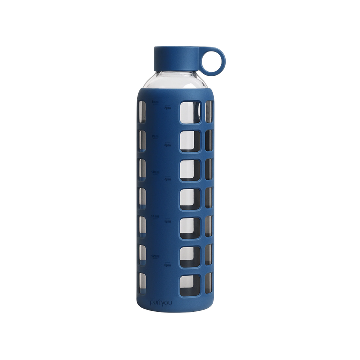 A blue reusable water bottle with a clear glass body, a blue silicone protective sleeve featuring square cutouts, a matching blue screw-on cap, and a small loop handle on the cap, shown on a plain white background.