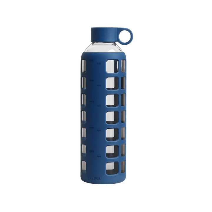 A blue reusable water bottle with a clear glass body, a blue silicone protective sleeve featuring square cutouts, a matching blue screw-on cap, and a small loop handle on the cap, shown on a plain white background.