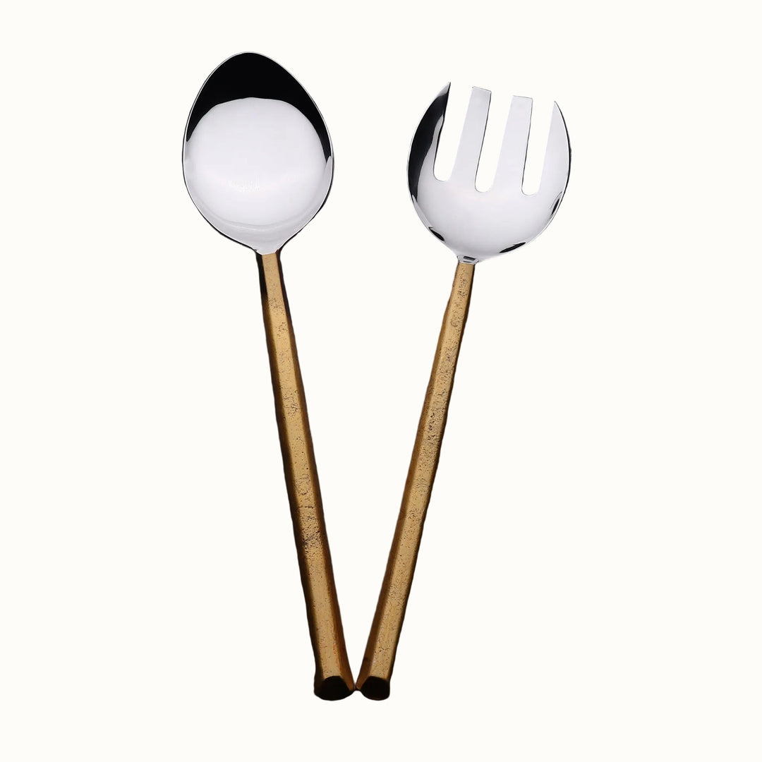 Two spoons, one with a round bowl and the other with a slotted design, on a dark gray background.