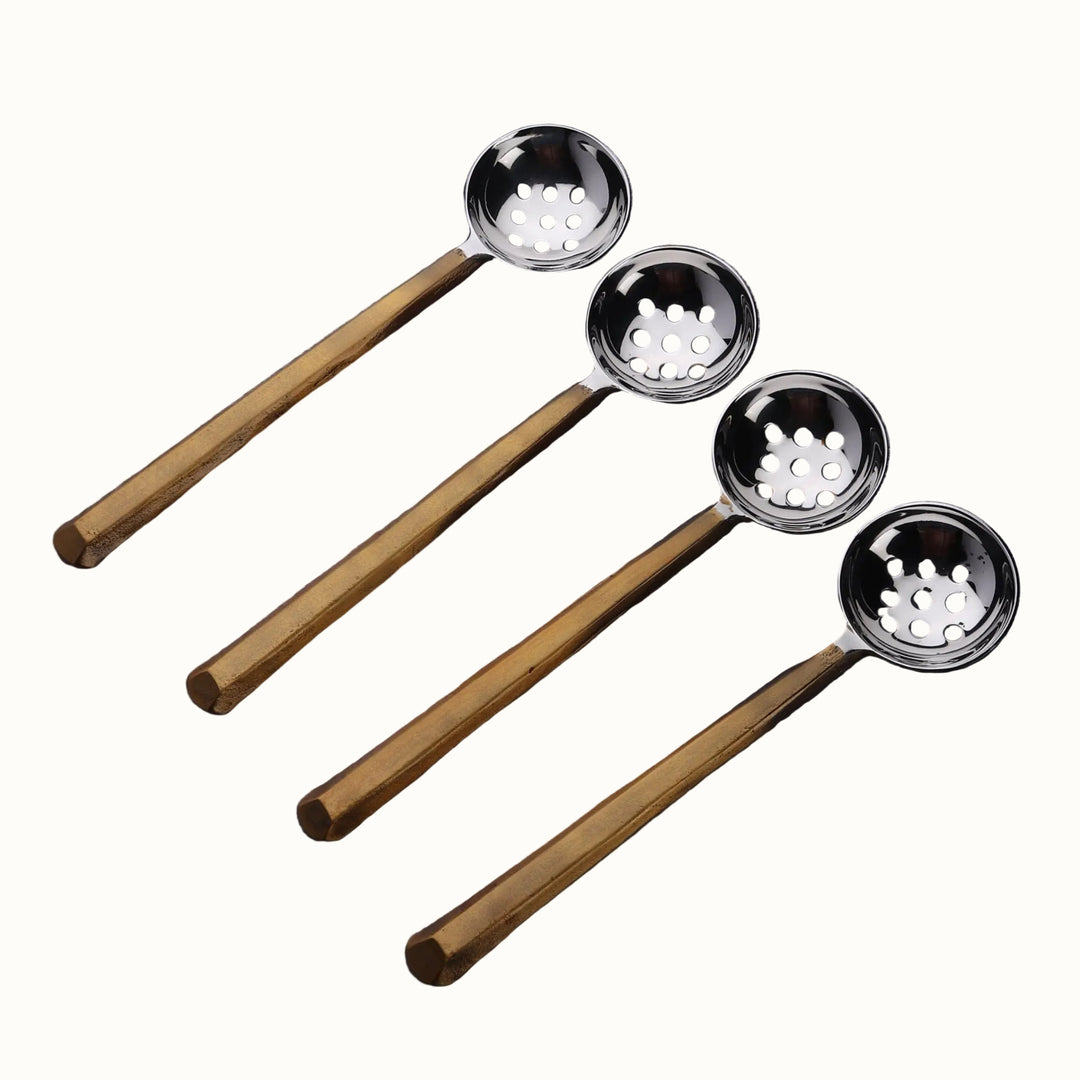 Set of four ladles with wooden handles on a wooden surface
