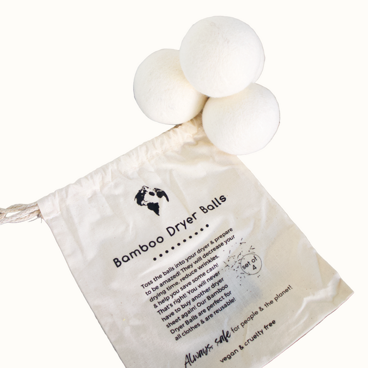 Bamboo dryer balls with a cloth bag on a wooden surface